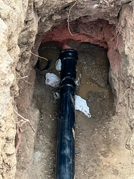 New black sewer pipe connected to an original clay sewer line in an excavation in Encino