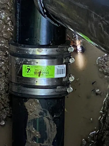 Close-up of a 4-inch shielded coupling on a repaired sewer line in Winnetka