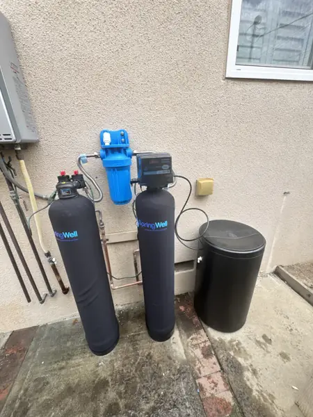 SpringWell whole-house water filter, water softener and brine tank installed on an outside wall in Studio City