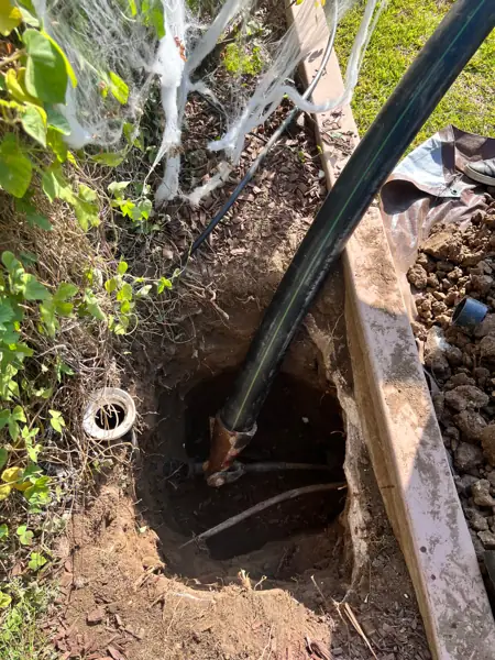 New black sewer pipe being pulled into an access pit during trenchless pipe bursting in Northridge