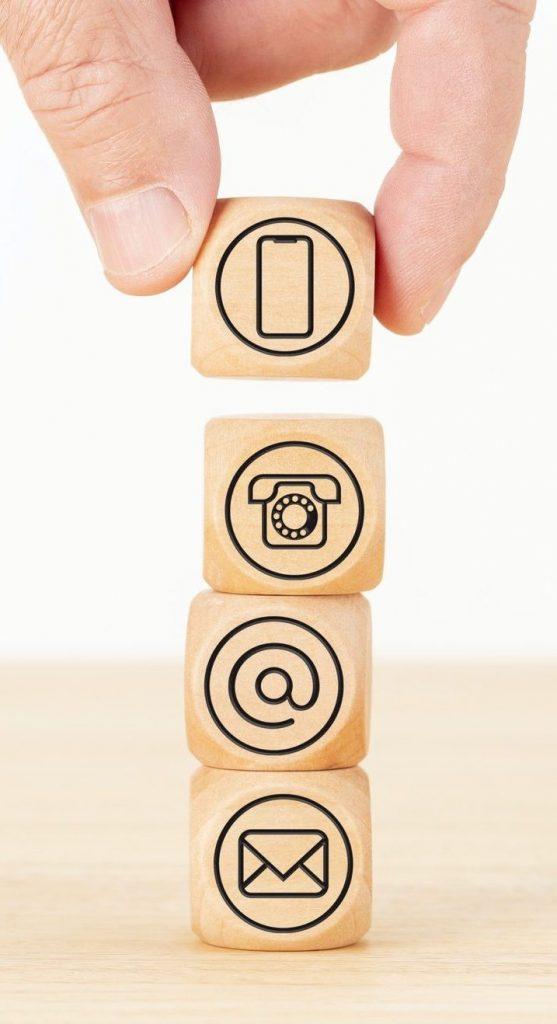 A hand is holding three wooden blocks with symbols on them.