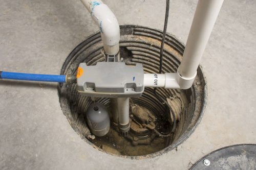 A sump pump system with pipes and wires in the floor.