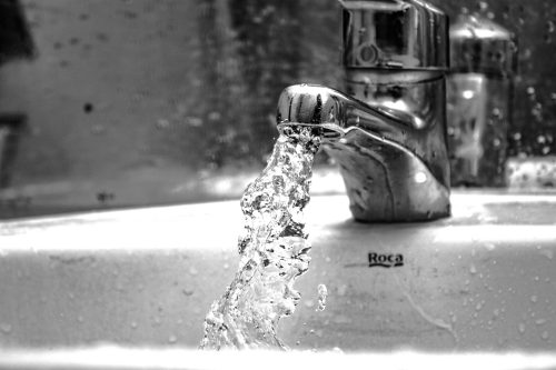 A faucet that is leaking water into the sink.